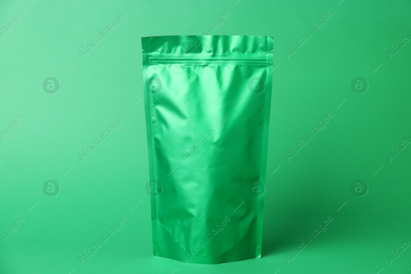 Photo of One zipper stand-up pouch on green background. Mockup for design