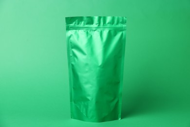 Photo of One zipper stand-up pouch on green background. Mockup for design