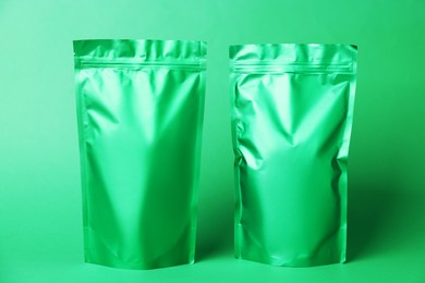 Photo of Zipper stand-up pouches on green background. Mockup for design