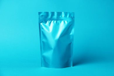 Photo of One zipper stand-up pouch on light blue background. Mockup for design
