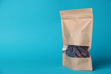 Photo of One zipper stand-up pouch with dry flowers on light blue background. Mockup for design