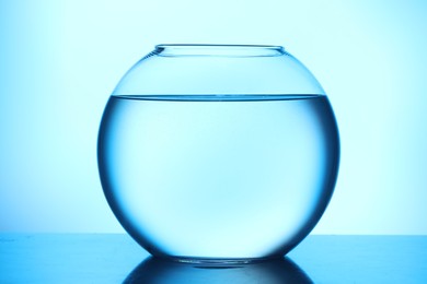 Photo of Glass aquarium with water on light blue background
