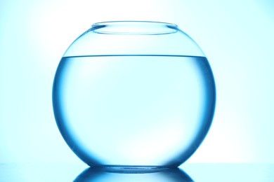 Photo of Glass aquarium with water on light blue background