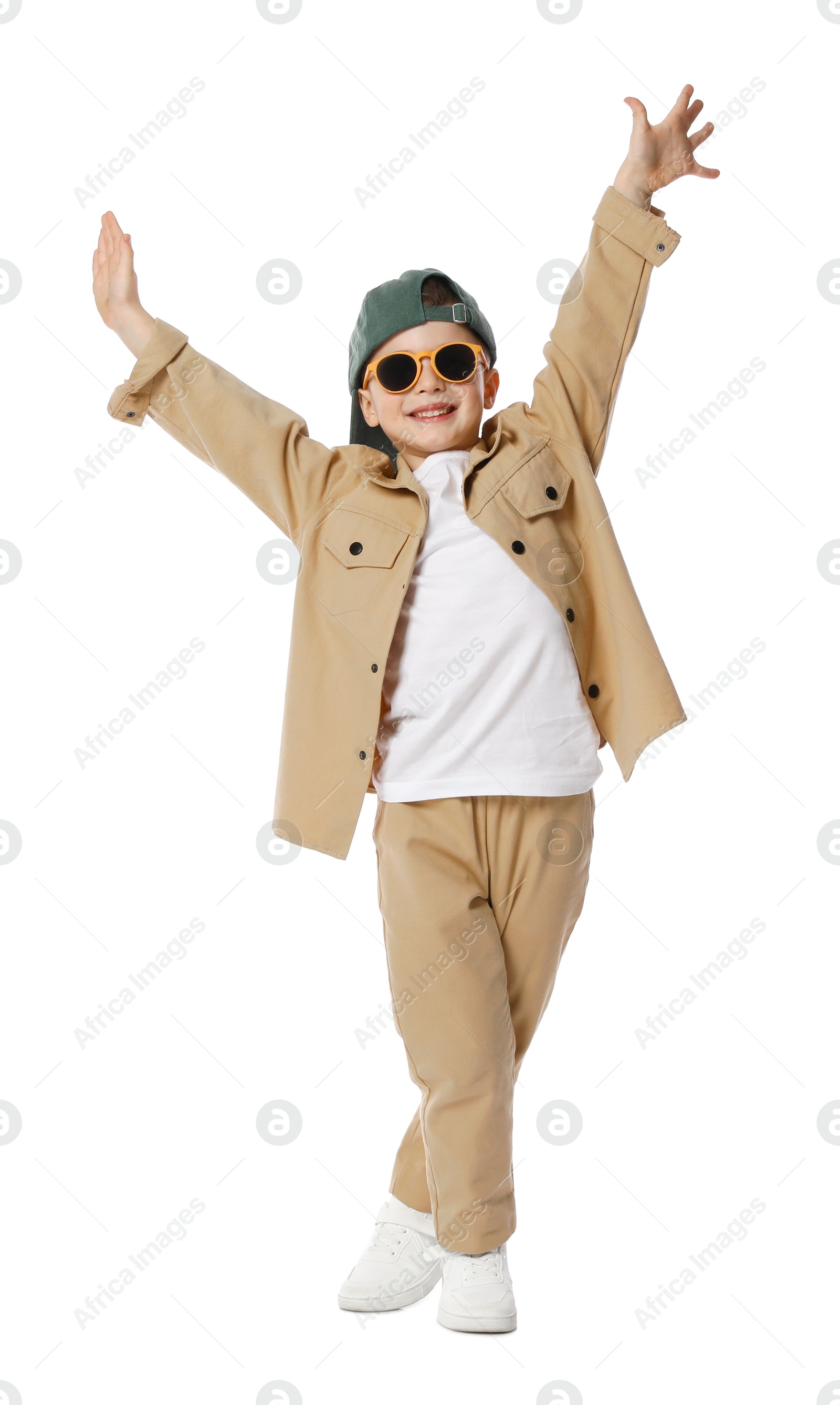 Happy little boy in sunglasses and baseball hat dancing on white background Photo of Happy little boy in sunglasses and baseball hat dancing on white background