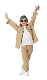 Photo of Happy little boy in sunglasses and baseball hat dancing on white background