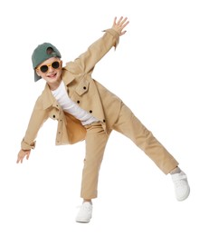 Photo of Happy little boy in sunglasses and baseball hat dancing on white background