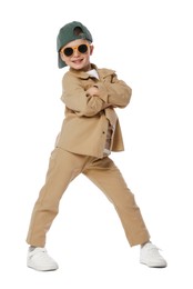 Photo of Happy little boy in sunglasses and baseball hat dancing on white background