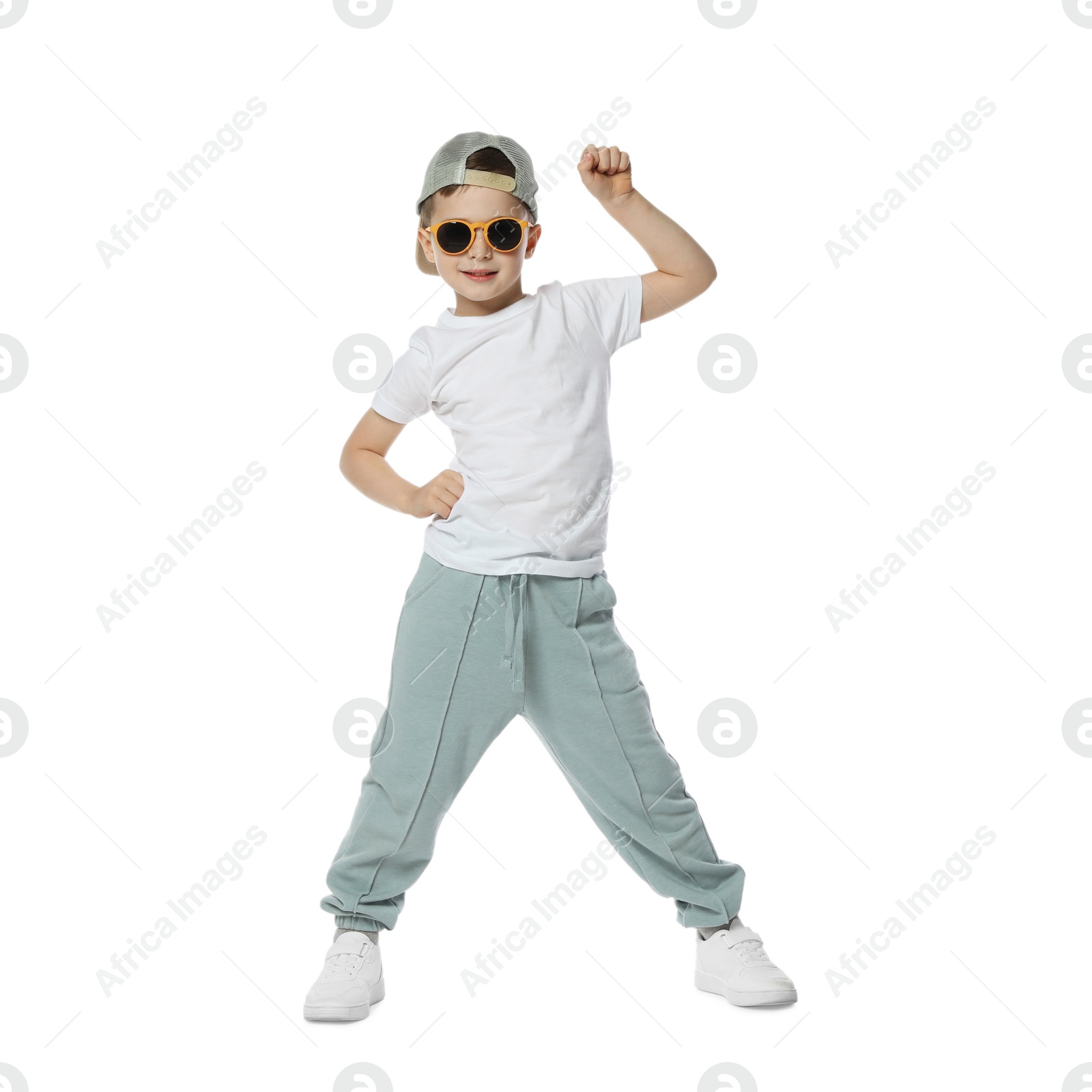Happy little boy in sunglasses and baseball hat dancing on white background Photo of Happy little boy in sunglasses and baseball hat dancing on white background