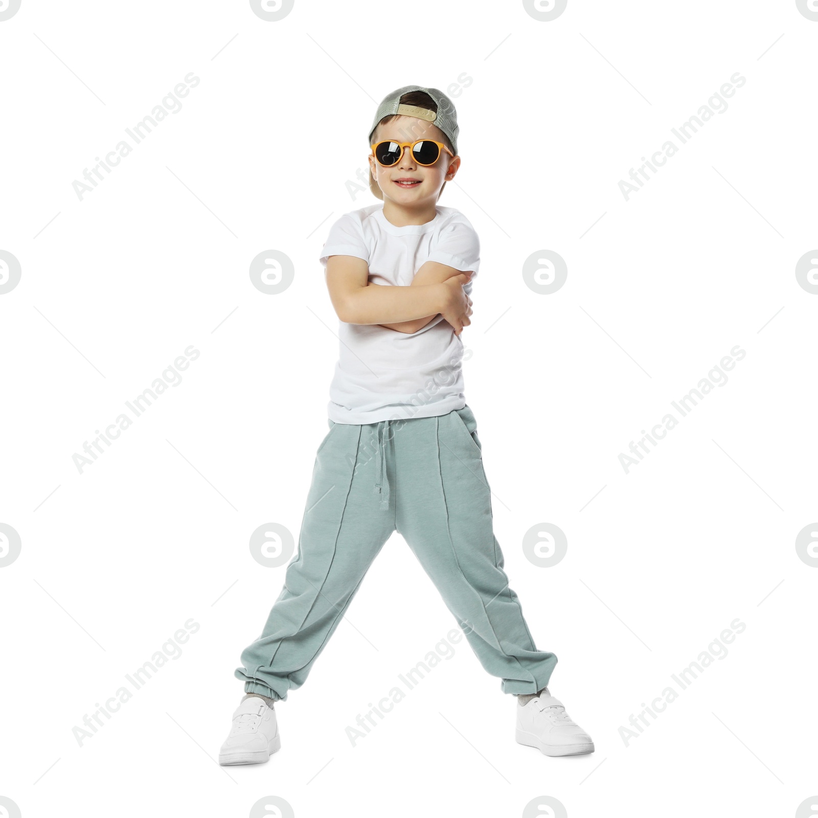 Happy little boy in sunglasses and baseball hat dancing on white background Photo of Happy little boy in sunglasses and baseball hat dancing on white background
