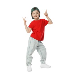 Photo of Happy little boy in baseball hat dancing on white background