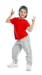 Photo of Happy little boy in baseball hat dancing on white background