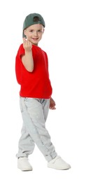 Photo of Happy little boy in baseball hat dancing and showing heart gesture on white background