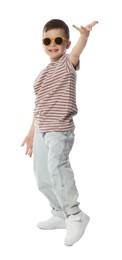 Photo of Happy little boy in sunglasses dancing on white background