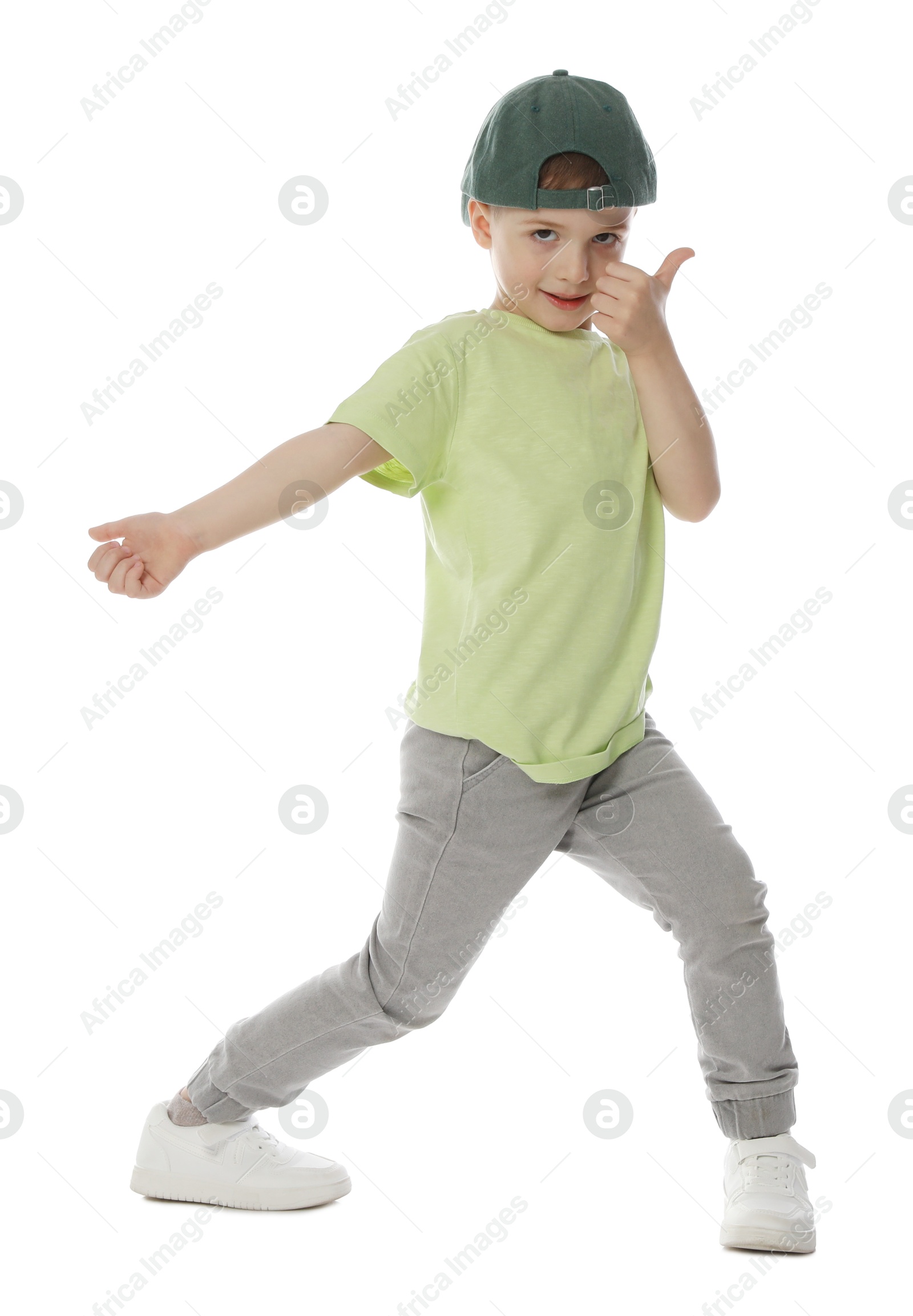 Happy little boy in baseball hat dancing on white background Photo of Happy little boy in baseball hat dancing on white background