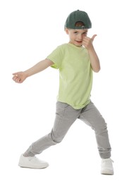 Photo of Happy little boy in baseball hat dancing on white background