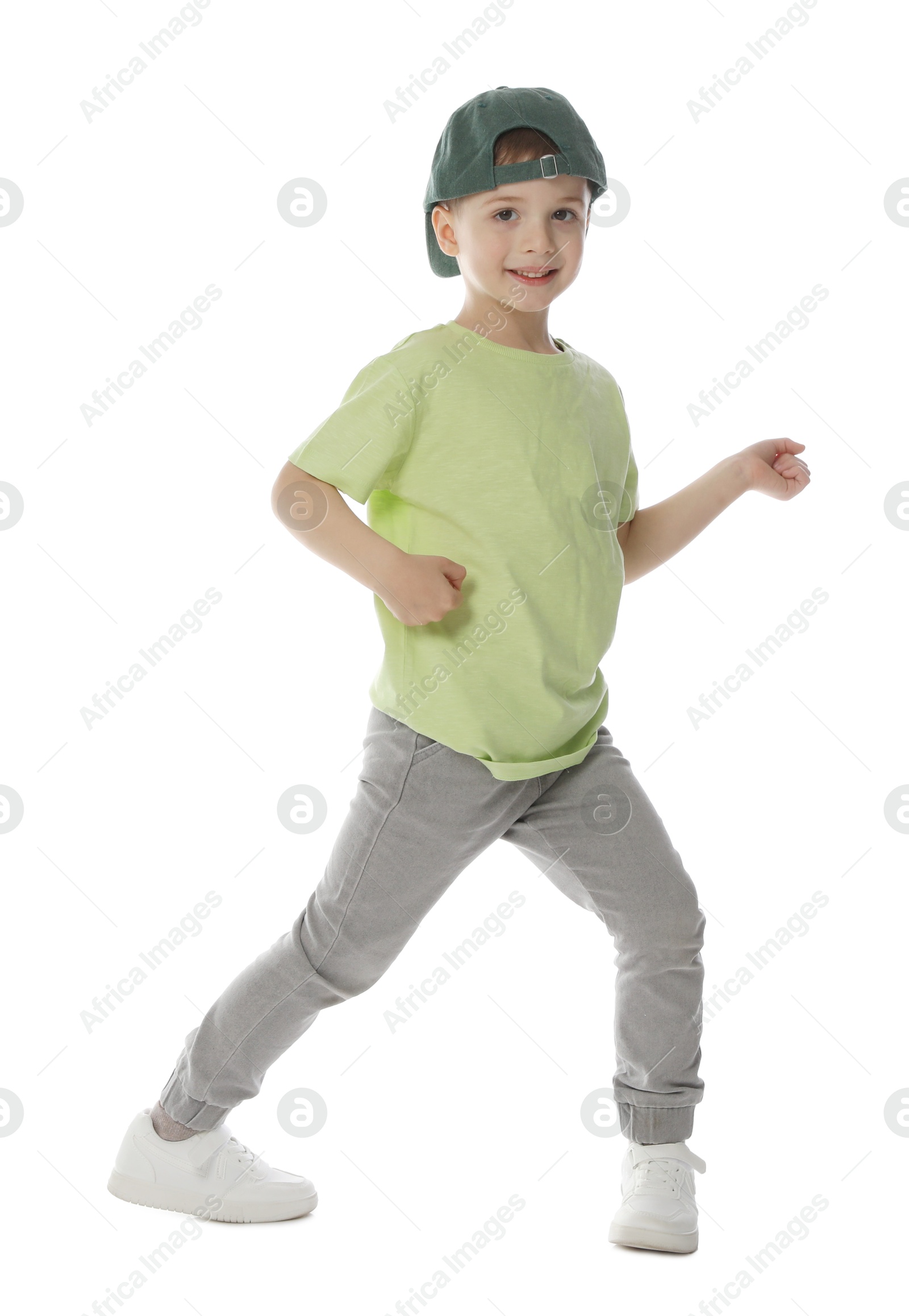 Happy little boy in baseball hat dancing on white background Photo of Happy little boy in baseball hat dancing on white background