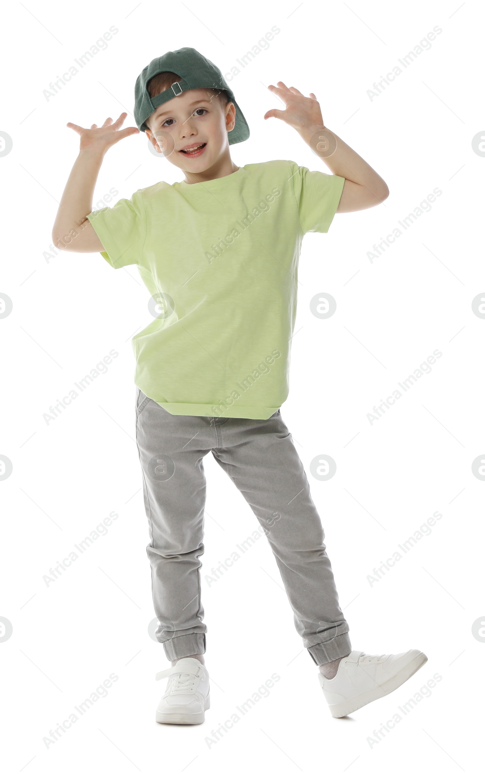 Happy little boy in baseball hat dancing on white background Photo of Happy little boy in baseball hat dancing on white background