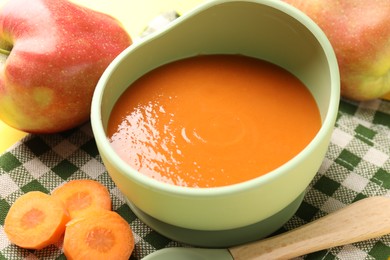 Photo of Baby food. Tasty puree in bowl and ingredients on table, closeup