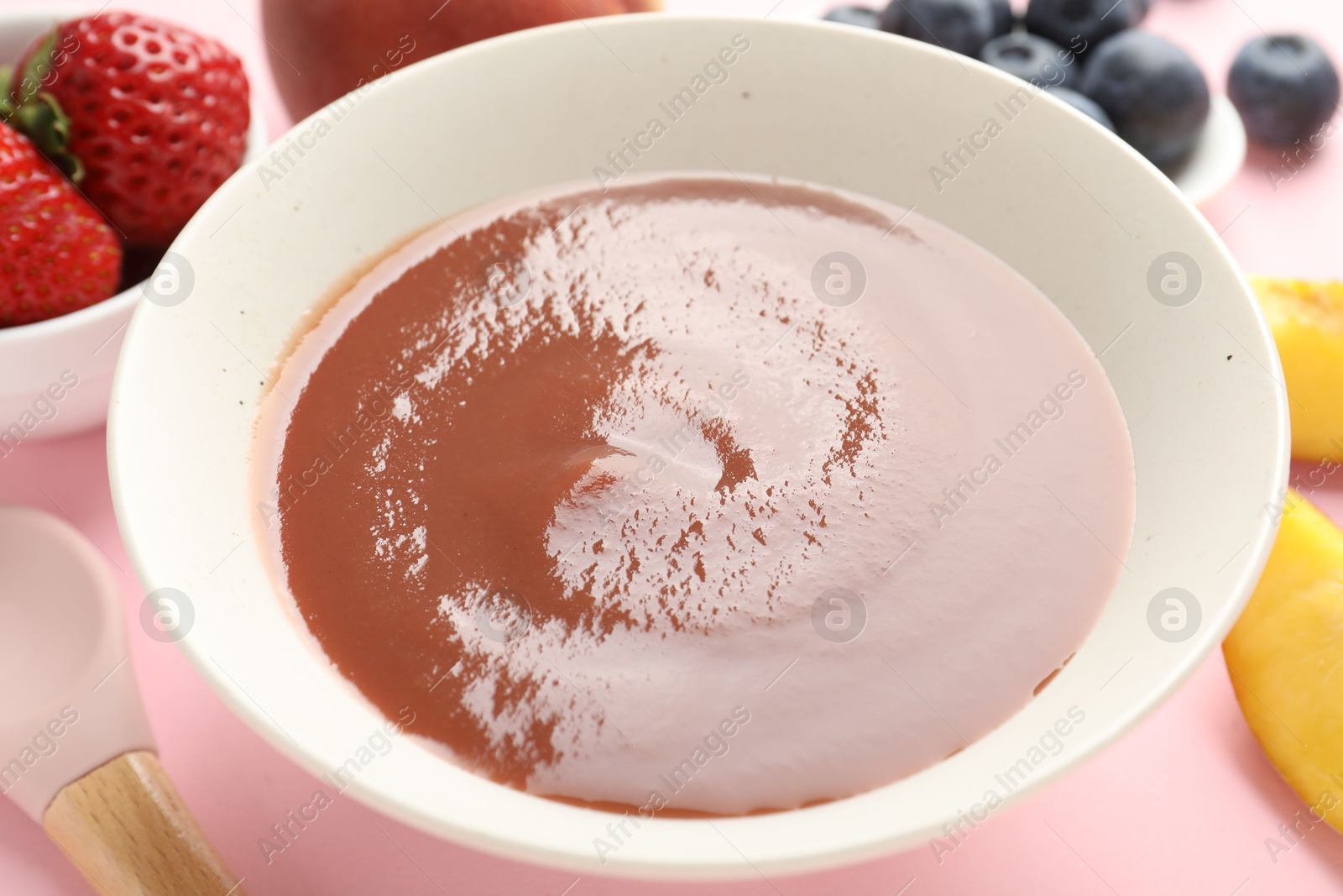 Baby food. Tasty puree in bowl and ingredients on pink background, closeup Photo of Baby food. Tasty puree in bowl and ingredients on pink background, closeup