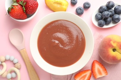 Photo of Baby food. Tasty puree in bowl, teether and ingredients on pink background, flat lay