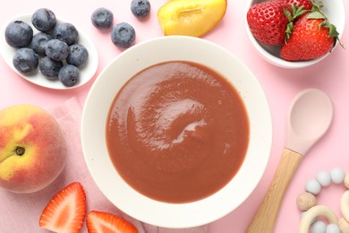 Photo of Baby food. Tasty puree in bowl, teether and ingredients on pink background, flat lay