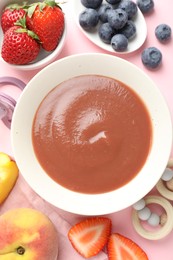 Photo of Baby food. Tasty puree in bowl, teether and ingredients on pink background, flat lay