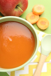 Photo of Baby food. Tasty puree in bowl and ingredients on green background, flat lay