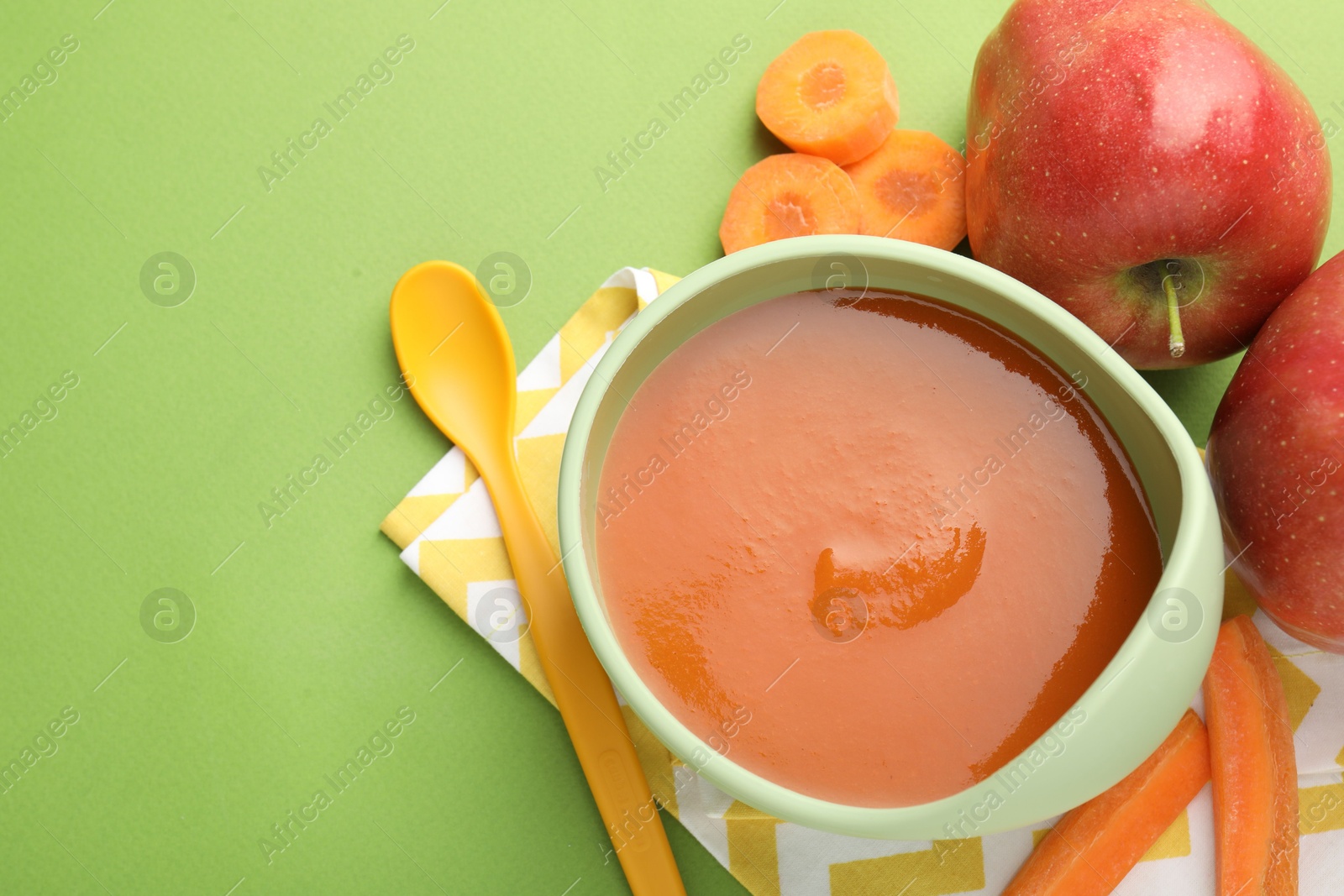 Baby food. Tasty puree in bowl and ingredients on green background, flat lay. Space for text Photo of Baby food. Tasty puree in bowl and ingredients on green background, flat lay. Space for text