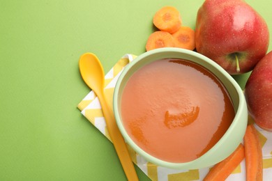 Photo of Baby food. Tasty puree in bowl and ingredients on green background, flat lay. Space for text