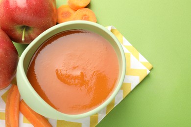 Photo of Baby food. Tasty puree in bowl and ingredients on green background, above view. Space for text