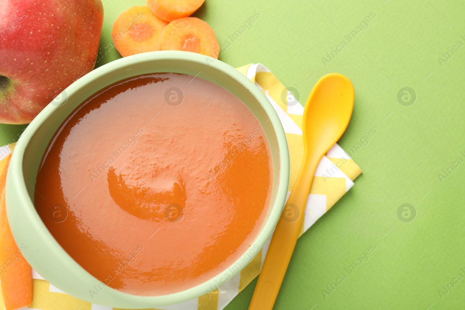 Baby food. Tasty puree in bowl and ingredients on green background, flat lay. Space for text Photo of Baby food. Tasty puree in bowl and ingredients on green background, flat lay. Space for text