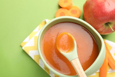 Photo of Baby food. Tasty puree in bowl and ingredients on green background, above view. Space for text