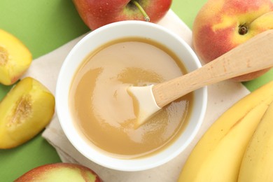 Photo of Baby food. Tasty puree in bowl and ingredients on green background, flat lay