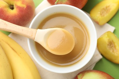 Photo of Baby food. Tasty puree in bowl and ingredients on green background, flat lay