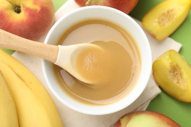 Photo of Baby food. Tasty puree in bowl and ingredients on green background, flat lay