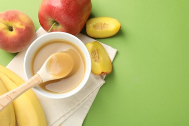 Photo of Baby food. Tasty puree in bowl and ingredients on green background, flat lay. Space for text