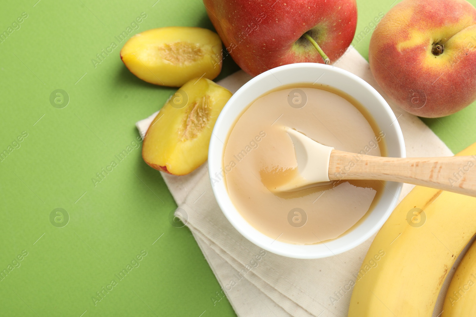 Baby food. Tasty puree in bowl and ingredients on green background, flat lay. Space for text Photo of Baby food. Tasty puree in bowl and ingredients on green background, flat lay. Space for text