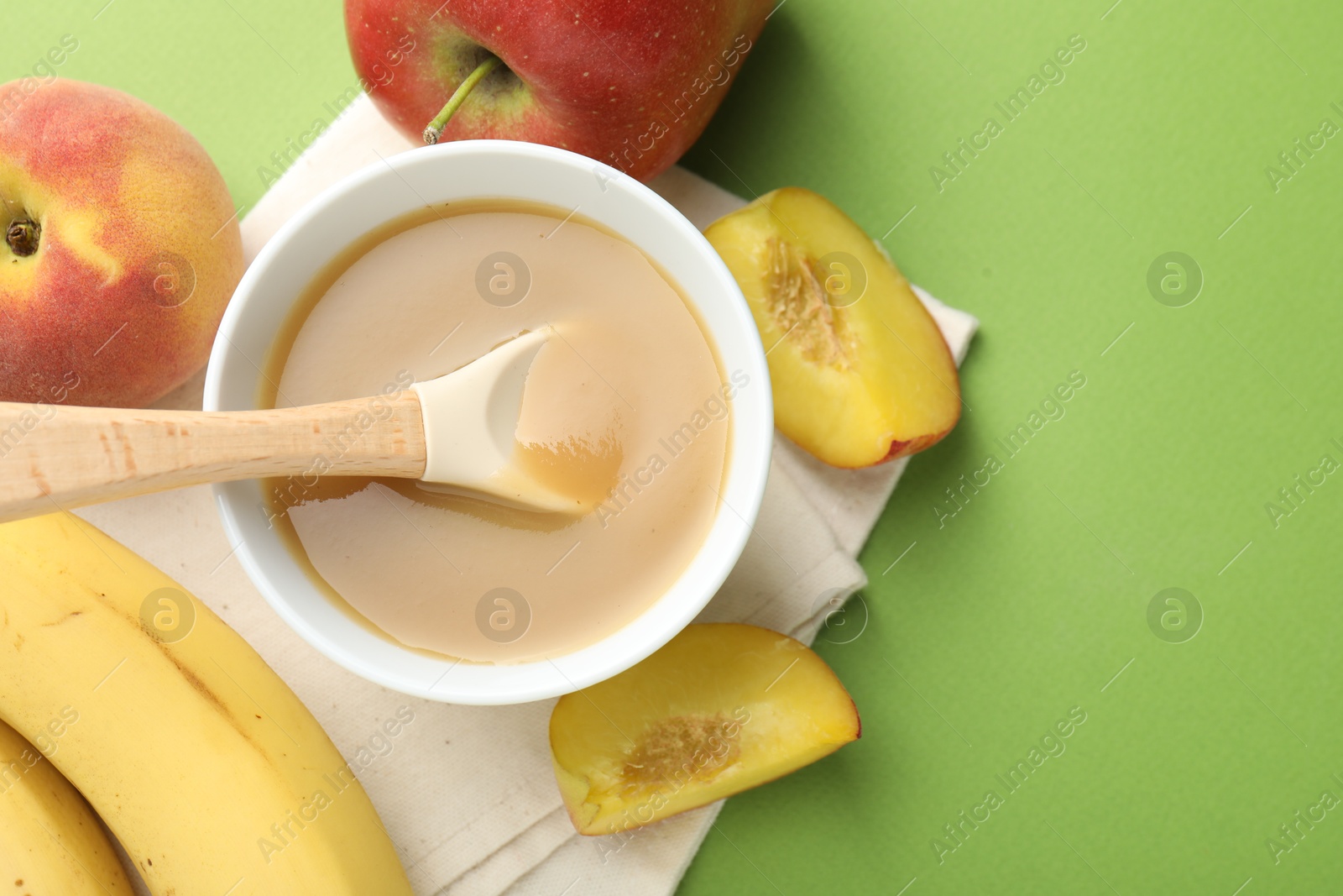 Baby food. Tasty puree in bowl and ingredients on green background, flat lay. Space for text Photo of Baby food. Tasty puree in bowl and ingredients on green background, flat lay. Space for text