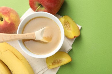 Photo of Baby food. Tasty puree in bowl and ingredients on green background, flat lay. Space for text