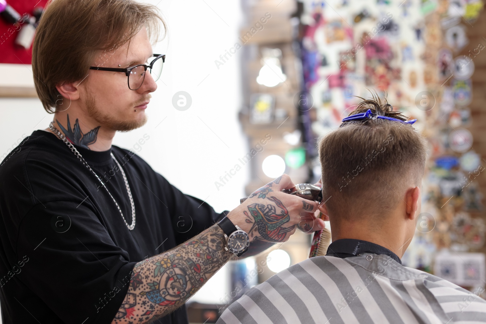 Professional barber making stylish haircut in barbershop Photo of Professional barber making stylish haircut in barbershop