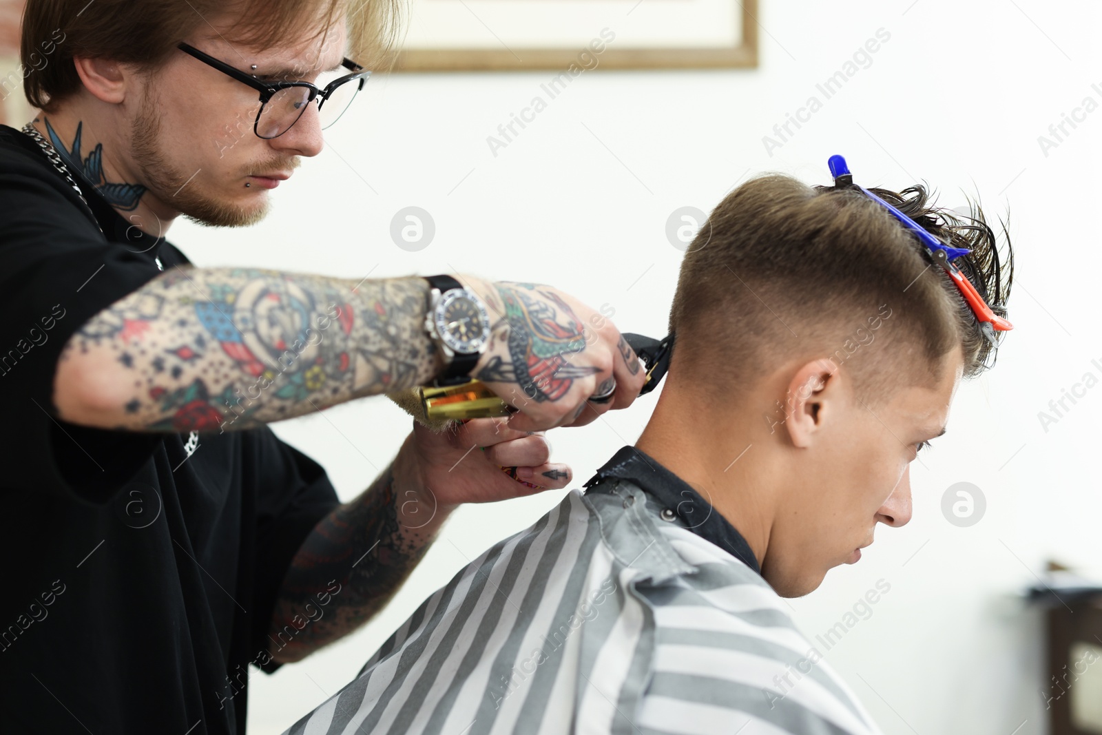 Professional barber making stylish haircut in barbershop Photo of Professional barber making stylish haircut in barbershop