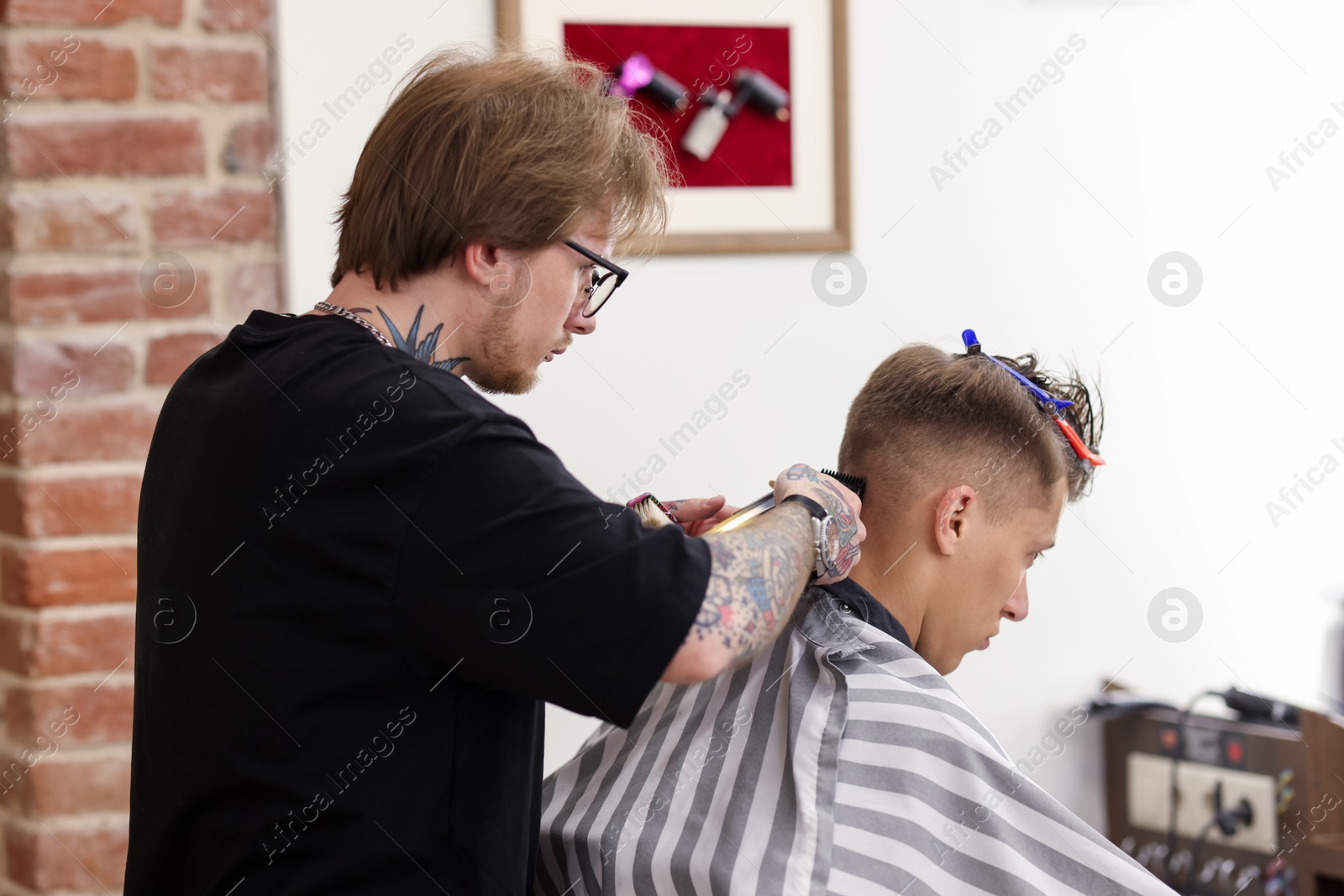 Professional barber making stylish haircut in barbershop Photo of Professional barber making stylish haircut in barbershop