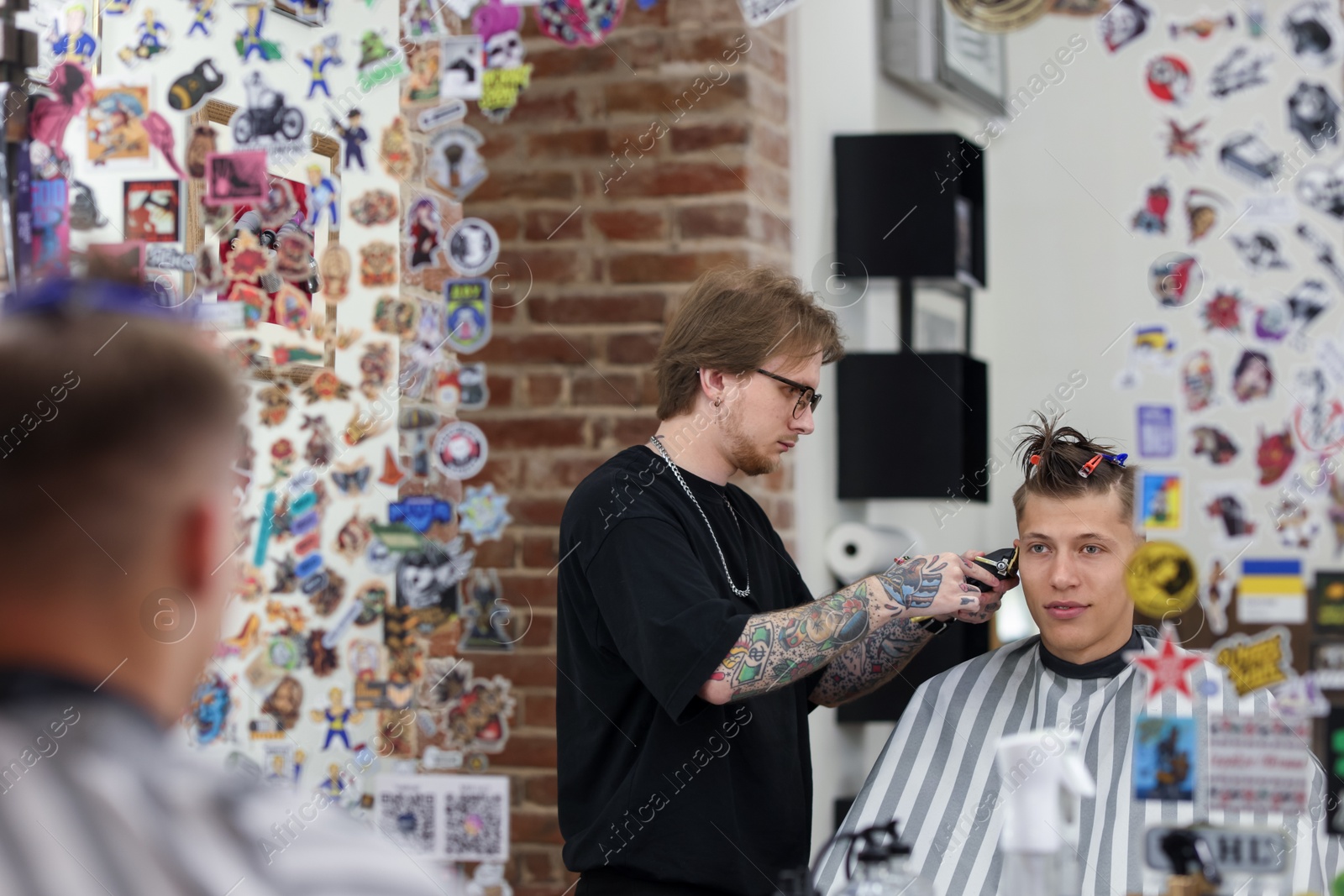 Professional barber making stylish haircut in barbershop Photo of Professional barber making stylish haircut in barbershop
