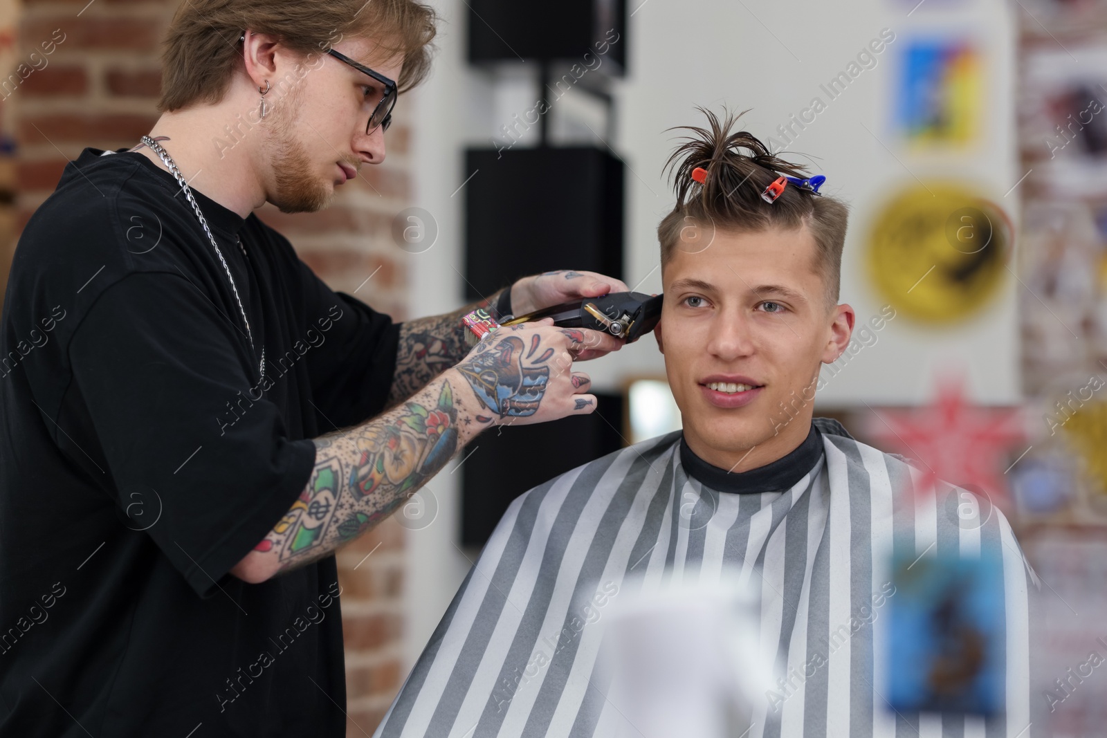 Professional barber making stylish haircut in barbershop Photo of Professional barber making stylish haircut in barbershop