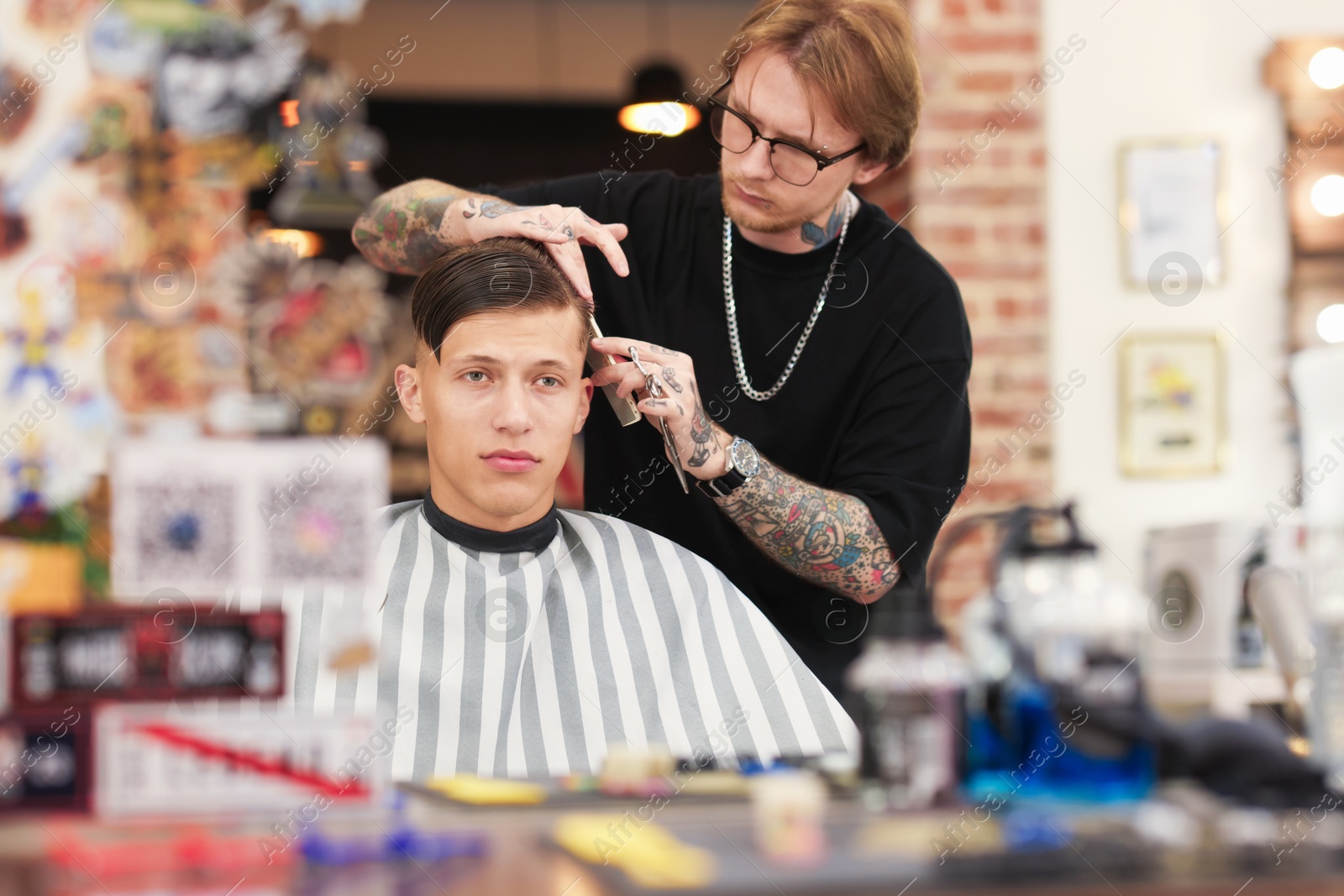 Professional barber making stylish haircut in barbershop Photo of Professional barber making stylish haircut in barbershop