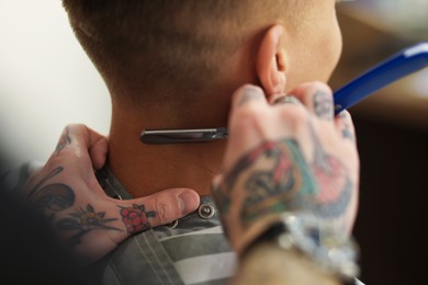 Photo of Professional barber working with client in barbershop, closeup