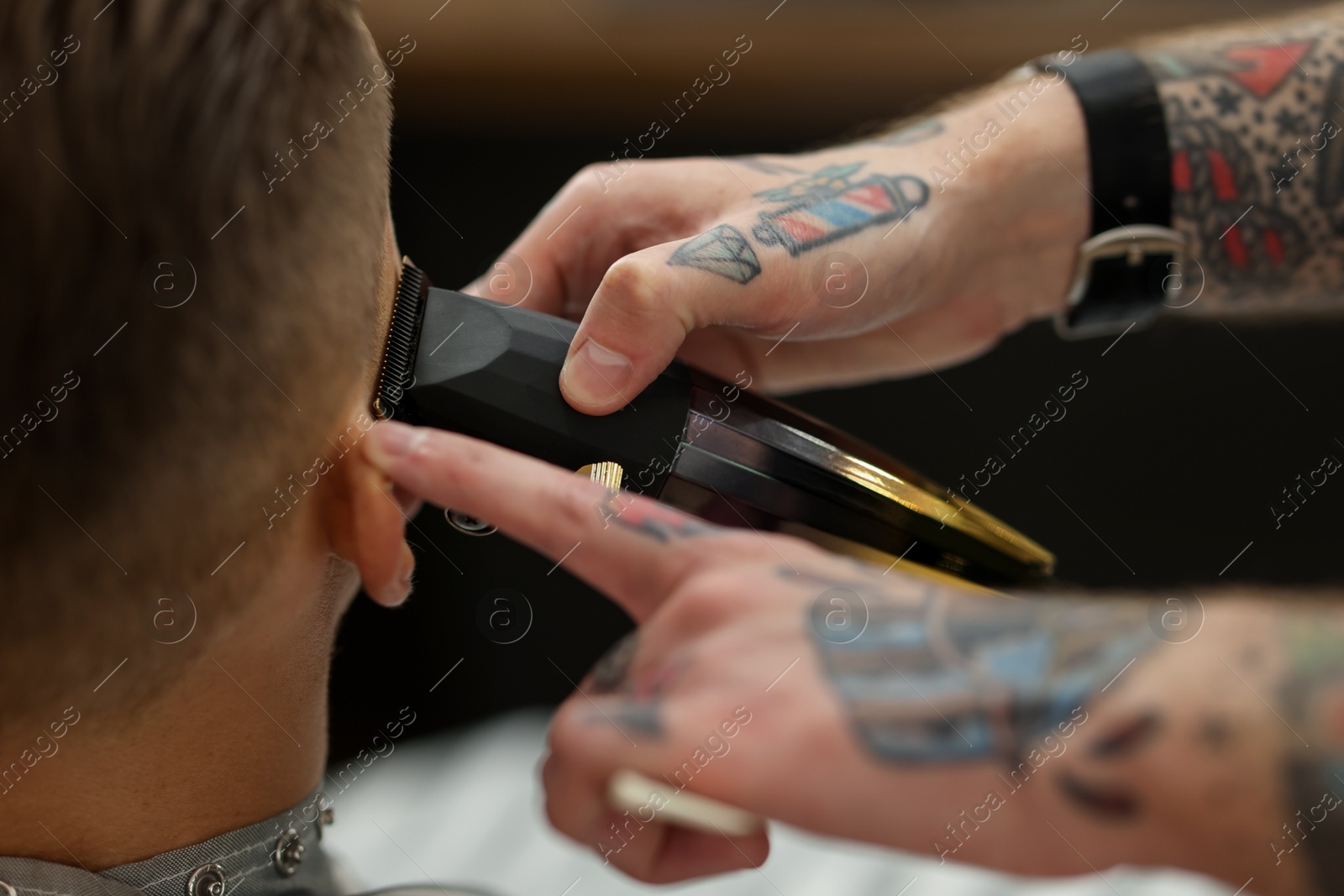 Professional barber working with client in barbershop, closeup Photo of Professional barber working with client in barbershop, closeup