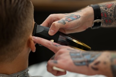 Photo of Professional barber working with client in barbershop, closeup