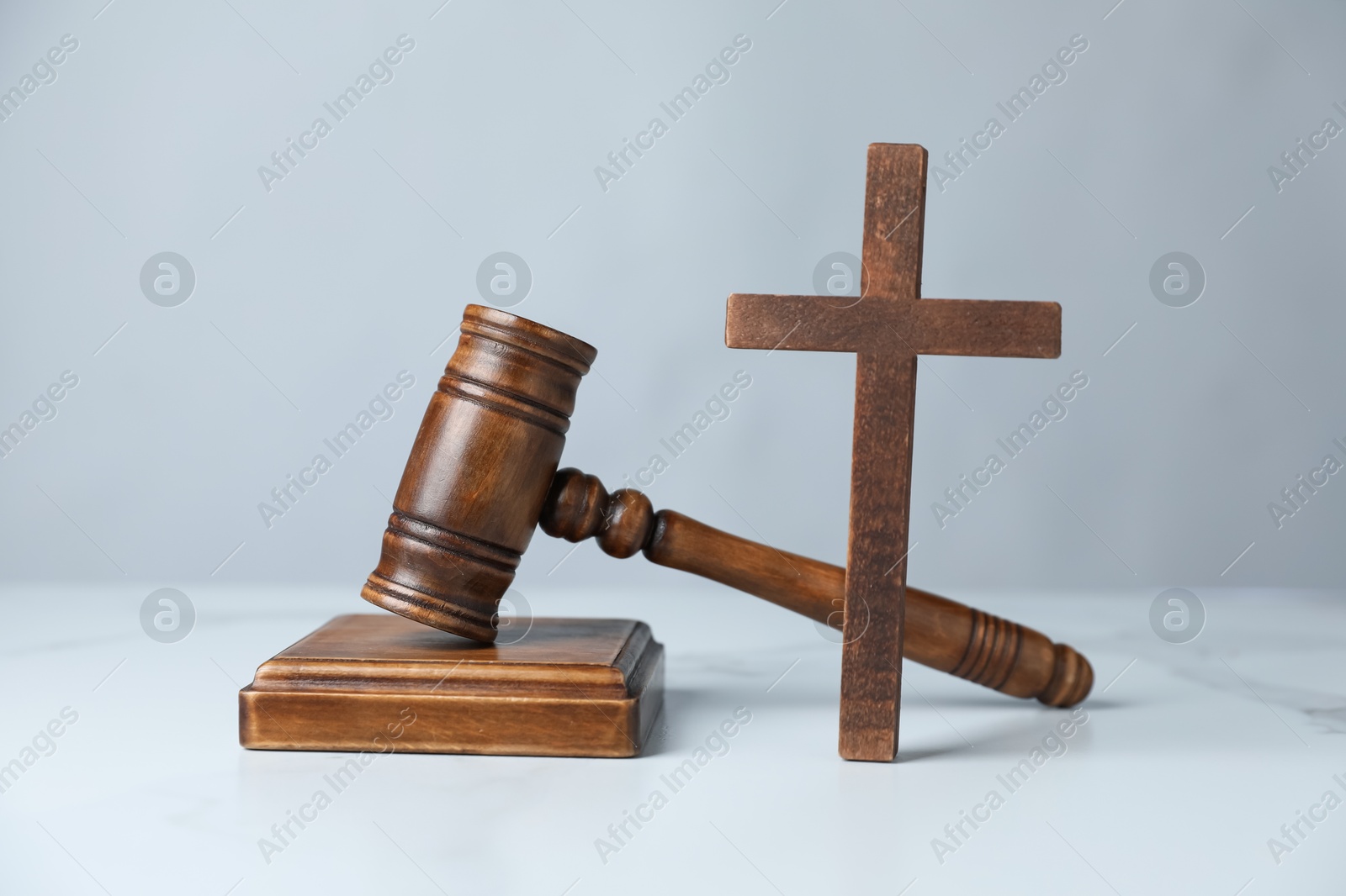 Judge's gavel and wooden cross on white marble table Photo of Judge's gavel and wooden cross on white marble table