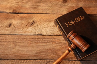 Photo of Judge's gavel and Bible on wooden table, above view. Space for text